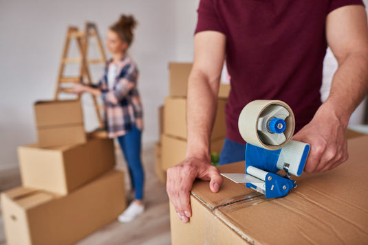 Couple packing labeled boxes while preparing for a move