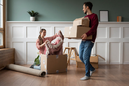 Moving crew carrying boxes from a home while everyone follows good moving day etiquette