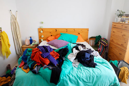 Packing bedroom belongings into labeled moving boxes before a move