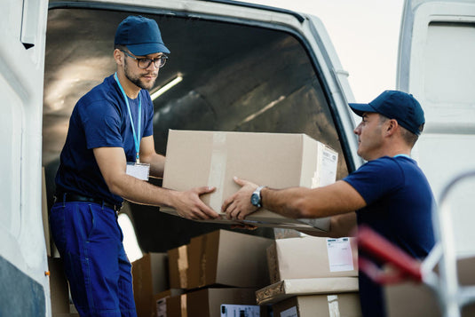 Homeowner handing a cash tip to movers after they finish unloading the moving truck