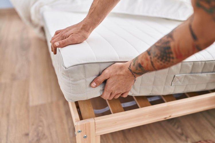 Person carrying a mattress in a protective bag while moving