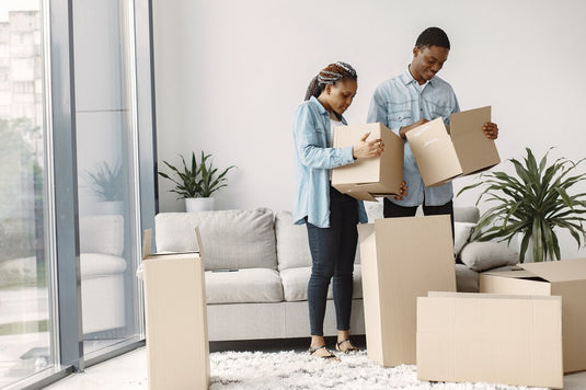 Young couple with cardboard boxes finding the cheapest way to move