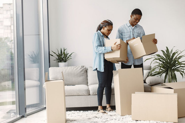 Young couple with cardboard boxes finding the cheapest way to move